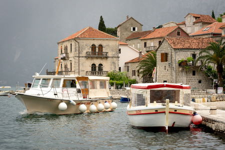 PERAST, MONTENEGRO - May 15, 2016: Perast city in Kotor bay with beautiful mountains and boat floating in Montenegroのeditorial素材