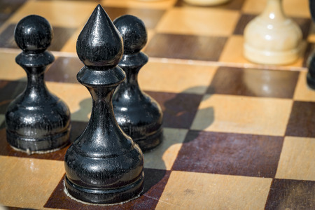black bishop and pawns figures standing on chessboardの写真素材