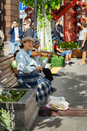 Moscow, Russia - July 10, 2016: Unidentified old woman musician play violin in the streetのeditorial素材