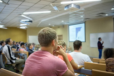 Rear view of business people listening attentively at conference.の写真素材
