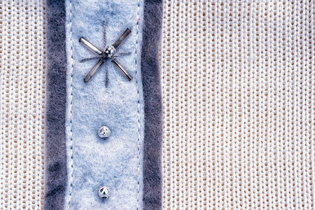 White knitting wool texture background with new year decorations pattern in the form of a snowflake made of beads and bugles and copy space for your inscriptionの写真素材