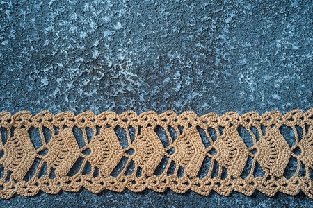 Lace embroidery ribbon on blue framed cement backgroundの写真素材