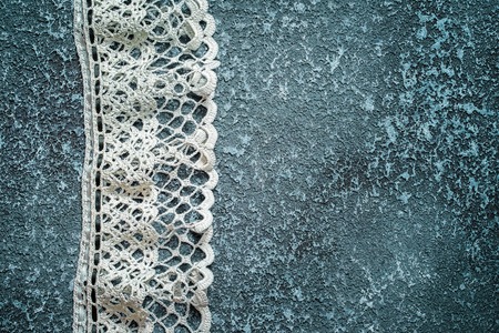 White lace on a dark cement background with copy space for your inscriptionの写真素材