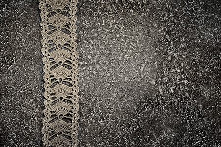 homemade crocheted lace on the grunge grey cement background, ideal for blog for needlework. possible to make a square layoutの写真素材