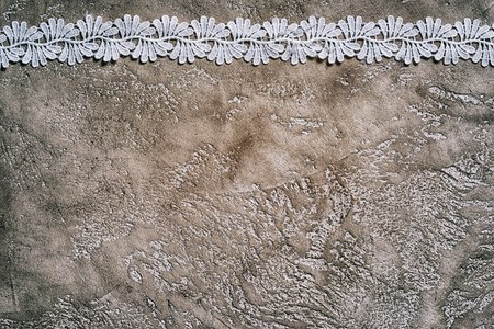 white lace border on a beige cement backgroundの写真素材