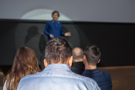Spokesperson speaks to an audience at a business conference. Free copy space for your vertical inscription to the right of the main picture.の写真素材