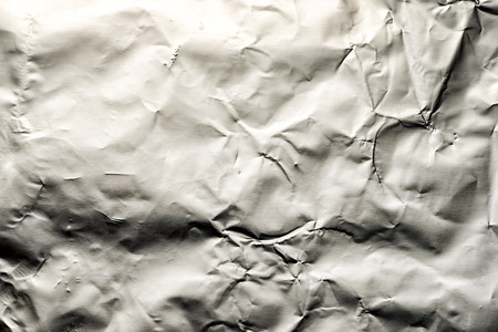 Thin sheet of silver leaf background with shiny uneven surfaceの写真素材