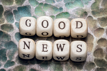 the word good news, lined with wooden blocks on a metal forged textural background.の写真素材