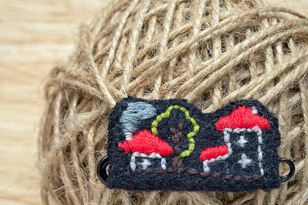 handmade embroidered houses - a brooch, on the background of the thread ballの写真素材