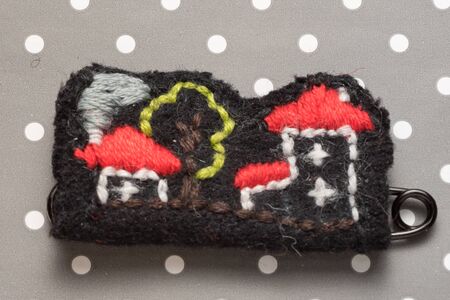 handmade embroidered brooch houses on a dots grey backgroundの写真素材