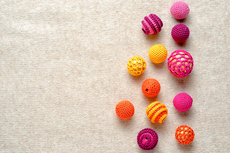 Multi-colored crocheted balls on a knitted background with copy space for your textの写真素材