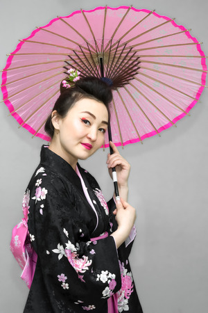 beautiful geisha in traditional japanese kimono with parasolの写真素材