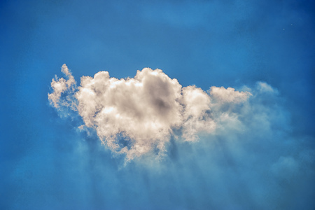One cloud, sunbeams and blue skyの写真素材