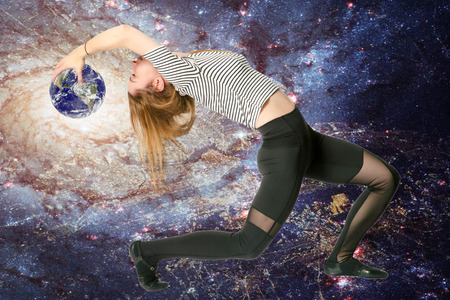 young athletic thin virgo zodiac girl curved back with the planet Earth ball on the galaxy background.の写真素材