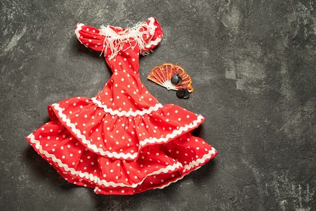 flamenco traditional dress for doll with fan and castanets on a black cement background, top view with copy spaceの写真素材