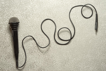 Classic microphone on a silver textured background