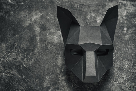 bending cardboard black wolf mask on a black background, top view with copy spaceの写真素材