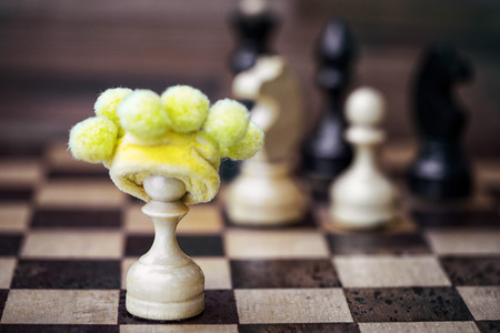chess pawn in foolish hat - business failure concept if works alone without team and opposes itself...