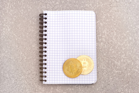 bitcoins on a little paper notebook on a table, top view with copy spaceの写真素材