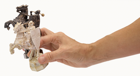 the course of the horse. chess pieces of toy riders on horses in hand isolated on white background.の写真素材