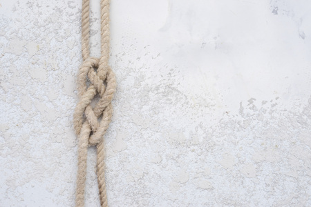 rope knot on a white textured concrete background, top view with copy spaceの写真素材