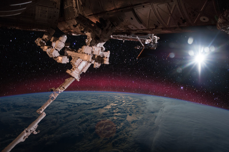 Spaceship on the orbit. Earth with clouds sunshine on the background.の写真素材