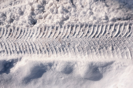Vehicle and tractor tire tread imprints on  the snowy road in winter, close up top view. One horizontal line with copy space at the top and bottom.の写真素材