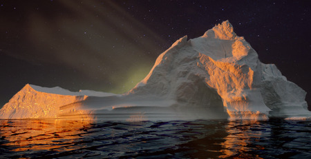 Iceberg with cave at night.