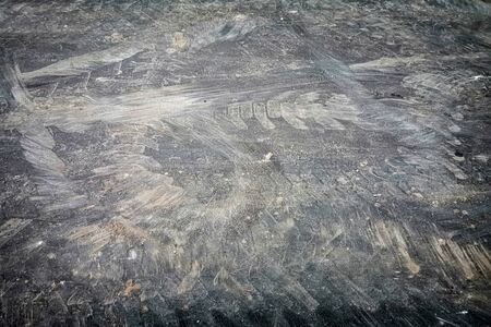 Dirty track imprints on asphalt, faded