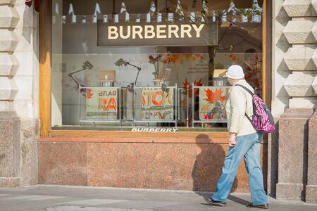 Moscow, Russia - October 03, 2019: Burberry storefront at the center of Moscow and poorly dressed woman walking by.のeditorial素材