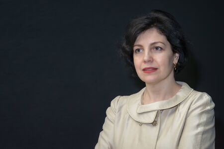 Pretty business woman in business suit against black wall.の写真素材