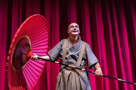 Moscow, Russia - November 11, 2019: Actor with umbrella on the stage during the Samurai sword performance in Moscow.のeditorial素材