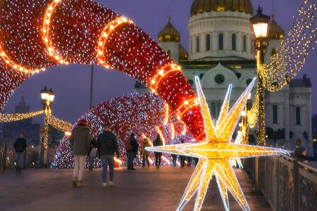 Moscow, Russia - December 29, 2019: Christmas decorations on the Patriarch's bridge on the background of the Cathedral of Christ the Savior in Moscow. Star of bethlehem.のeditorial素材