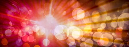 Abstract light circular bokeh background in red and yellow colors and light rays.の写真素材