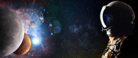 Concept of an astronaut looking up into the stars and solar system planets. Sci-fi space exploration collage,の写真素材