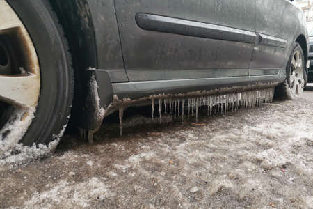 Close up car parked on the street in spring, with lots of icicles.の写真素材