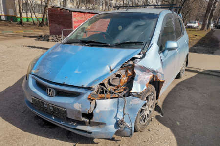 Moscow, Russia - April 04, 2021: Honda car after a car accident parked on the street, headlamp broken, rusty and old.のeditorial素材