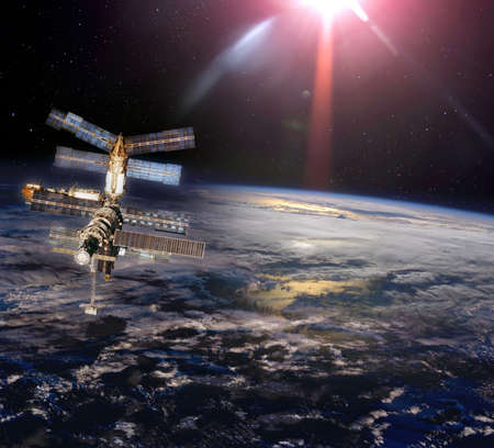 Space station under cloudy earth in space.の写真素材