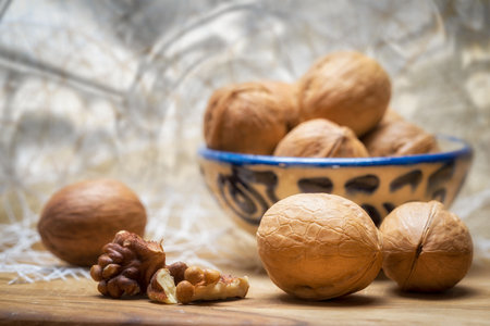 Food background. Walnut chopped nuts kernels and whole walnuts lie on a wooden table.の写真素材