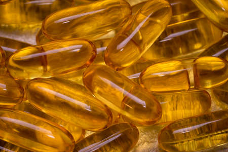 Omega-3 fish fat oil capsules as background texture. EPA and DHA are essential fatty substances that our bodies need on a daily basis.の写真素材