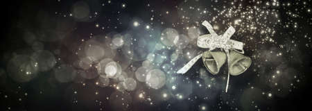 Jingle bells on abstract light circular bokeh background. New year and Christmas conceptual postcard with copy space.の写真素材