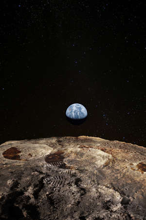 Footsteps on the moon surface, Earth rises above lunar horizon.の写真素材