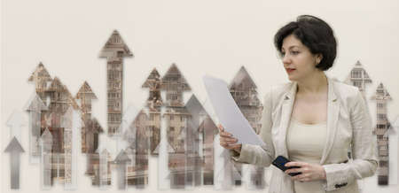 Successful confidence middle aged business woman reading papers on a background with arrows up skyscapers. business growth concept.の写真素材