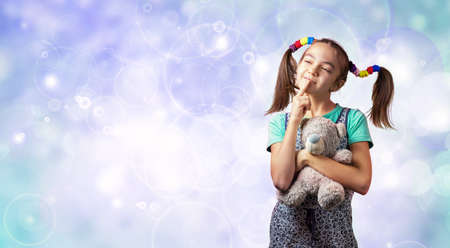 11 year old girl with a toy bear thought on the background of circles with copy spaceの写真素材