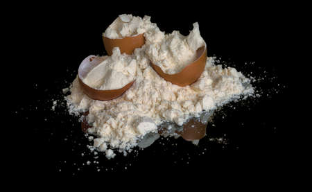 Egg protein powder heap and egg shells isolated on black background with mirror reflection on the table. sports nutrition.の写真素材