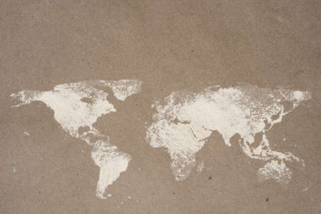 World map dusted on flour craft paper with copy space. World food safety concept.の写真素材