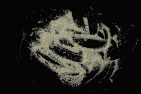 Black background sprinkled with flour, smeared flour, table for cooking, rolling dough. Preparing for baking, top view on a black background or table.の写真素材