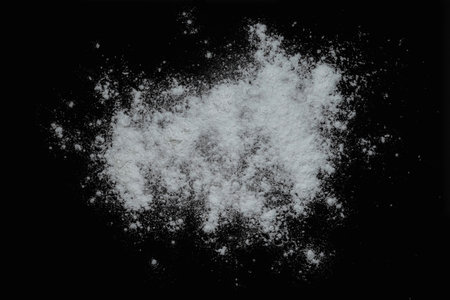 Black background sprinkled with flour, smeared flour, table for cooking, rolling dough. Preparing for baking, top view isolated on a black background or table.の写真素材