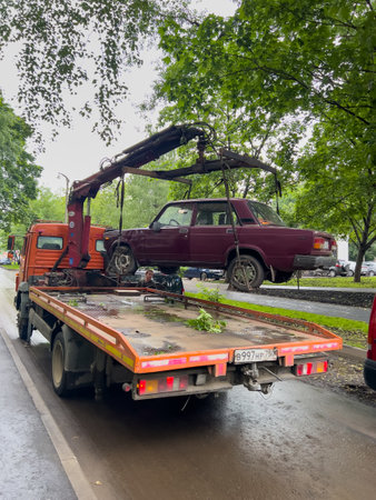 Moscow, Russia - June 21, 2022: tow truck lifts a passenger car for further evacuation