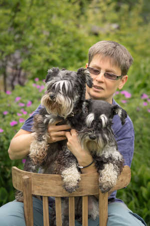 Woman with two miniature schnauzer dogs portraitの写真素材
